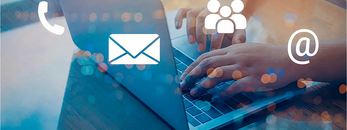 Persona escribiendo en laptop con íconos superpuestos de teléfono, sobre, arroba y grupo de personas