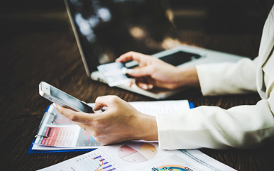 Persona utilizando banca digital en computadora y celular para invertir en fondos del Banco Nacional de Costa Rica BNCR.